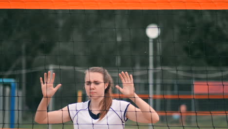 Young-woman-playing-volleyball-on-the-beach-in-a-team-carrying-out-an-attack-hitting-the-ball.-Girl-in-slow-motion-hits-the-ball-and-carry-out-an-attack-through-the-net.